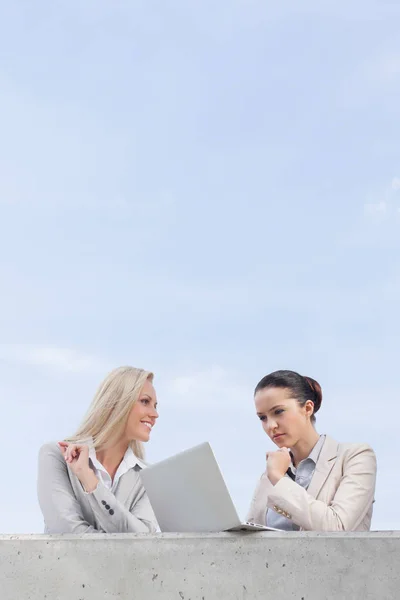 Empresaria usando laptop con compañero de trabajo — Foto de Stock