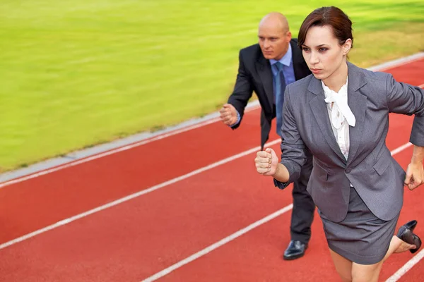 Businessman and woman on race track — Stock Photo, Image