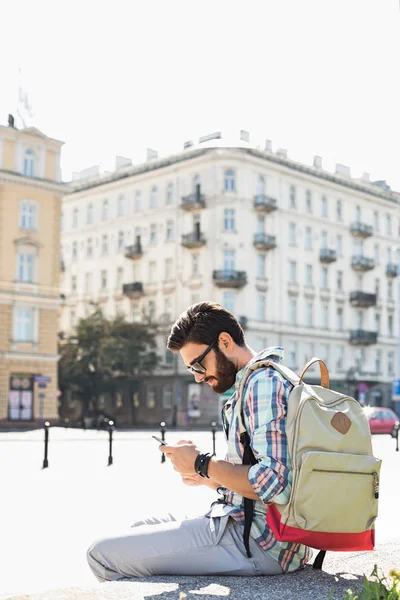 Man with backpack using cell phone — Stock Photo, Image