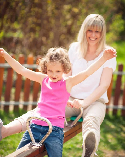 Mother and daughter ride seesaw — Stock Photo, Image