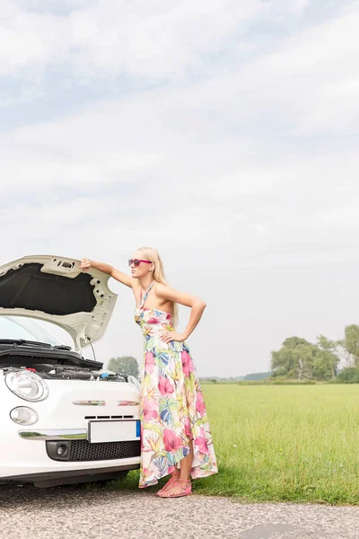 Angespannte Frau steht vor Auto — Stockfoto