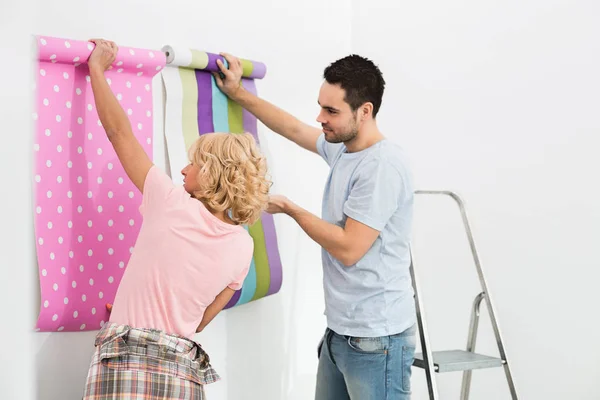 Pareja sosteniendo muestras de papel pintado — Foto de Stock