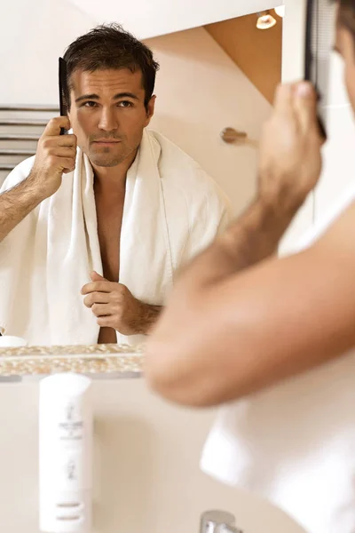 Hombre peinándose el pelo — Foto de Stock