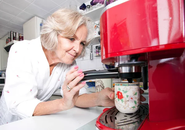 Seniorin schenkt Kaffee aus — Stockfoto