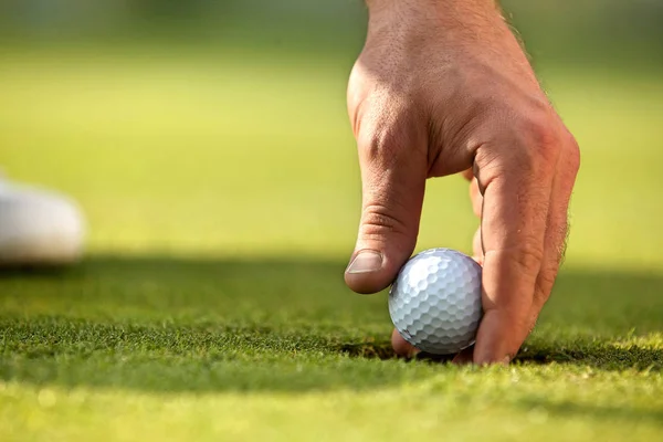 Person som innehar golfboll — Stockfoto