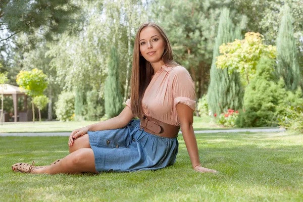 Mulher sentada na grama no parque — Fotografia de Stock