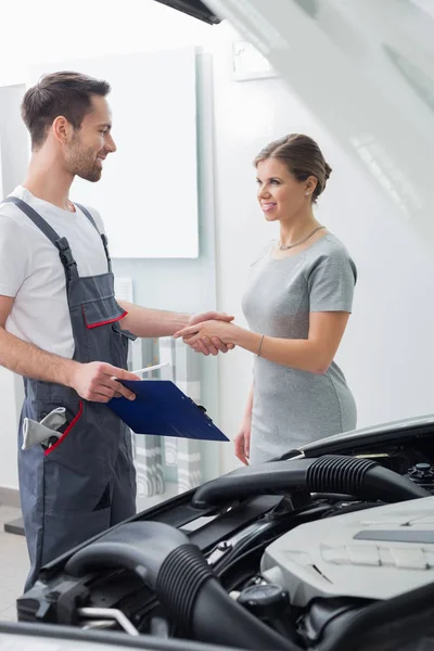 Worker shaking hands with customer — Stock Photo, Image