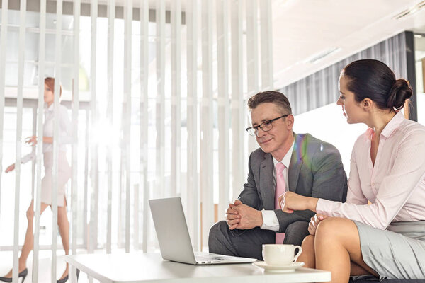 Бизнесмен и деловая женщина обсуждают