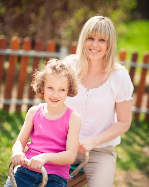 Mother and daughter ride seesaw — Stock Photo, Image