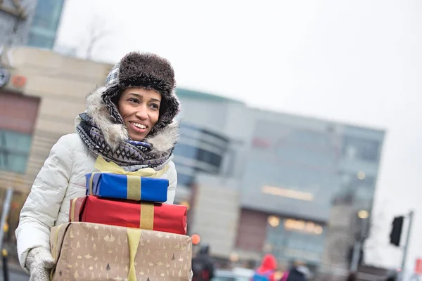 Femme heureuse portant des cadeaux empilés — Photo