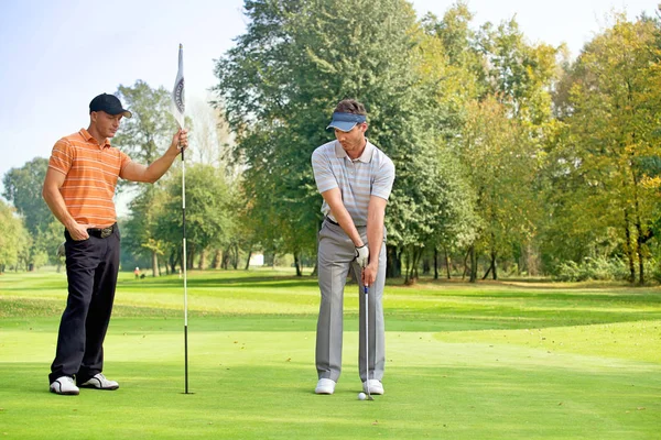 Muž s přítelem hrát golf — Stock fotografie