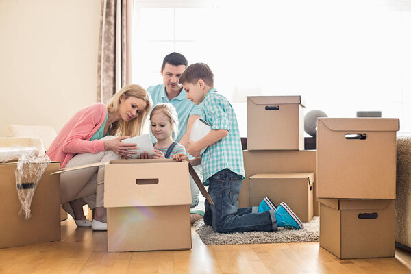 Семья распакует картонные коробки

