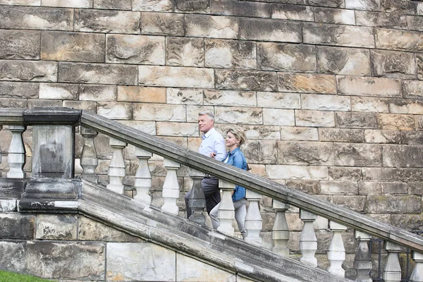 middle-aged couple climbing steps