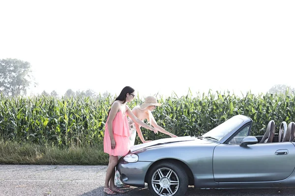 Female friends reading map on convertible — Stock Photo, Image