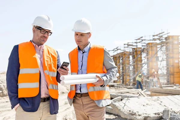 Ingenieros masculinos usando teléfono móvil — Foto de Stock