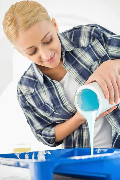 Woman pouring paint in container — Stock Photo, Image