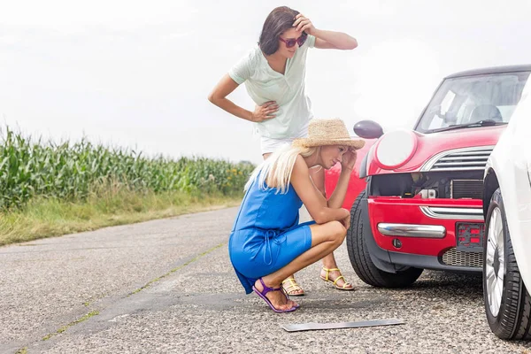 紧张的妇女看着坏了的汽车 — 图库照片