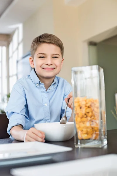 Sorridente ragazzo mangiare corn flakes — Foto Stock