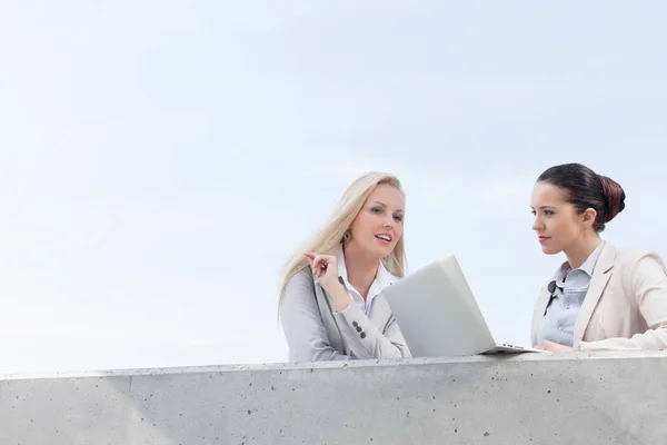 Unga affärskvinnor med laptop diskuterar — Stockfoto