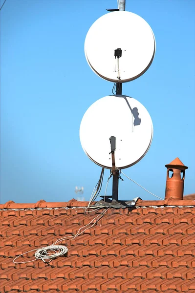 Parabole satellitari su un tetto piastrellato — Foto Stock