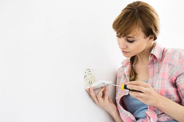 Donna che lavora sulla presa elettrica — Foto Stock