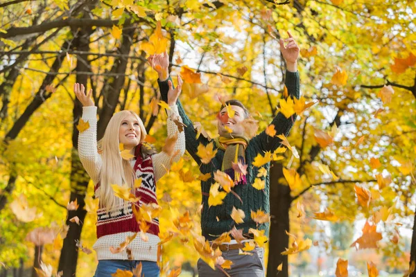 Pareja disfrutando de caída hojas de otoño — Foto de Stock