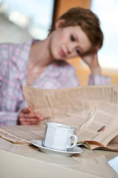 Nainen lukee sanomalehteä — kuvapankkivalokuva