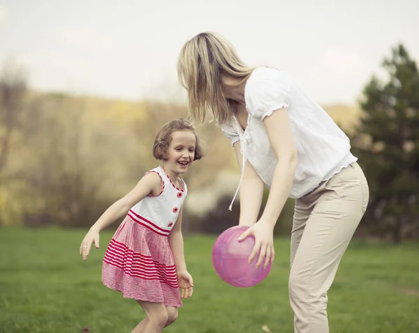 Moeder en dochter spelen met de bal — Stockfoto