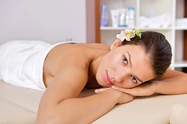 Mulher relaxante na mesa de massagem — Fotografia de Stock