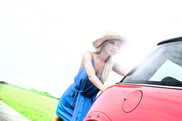 Mulher empurrando quebrado para baixo carro — Fotografia de Stock