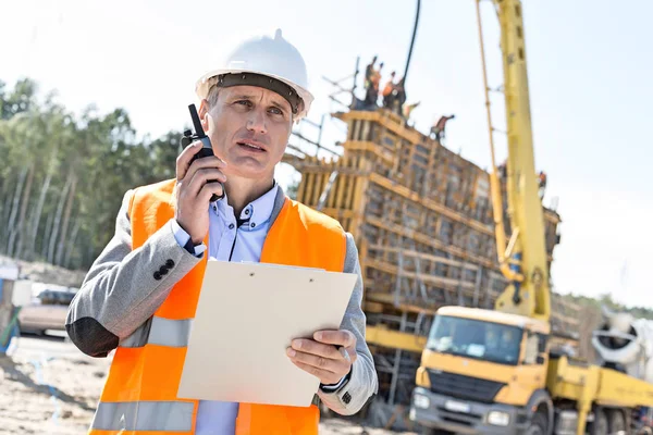 Supervisor usando walkie-talkie no local de construção — Fotografia de Stock