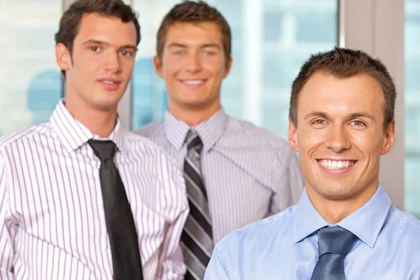 Trois hommes d'affaires souriant au bureau — Photo