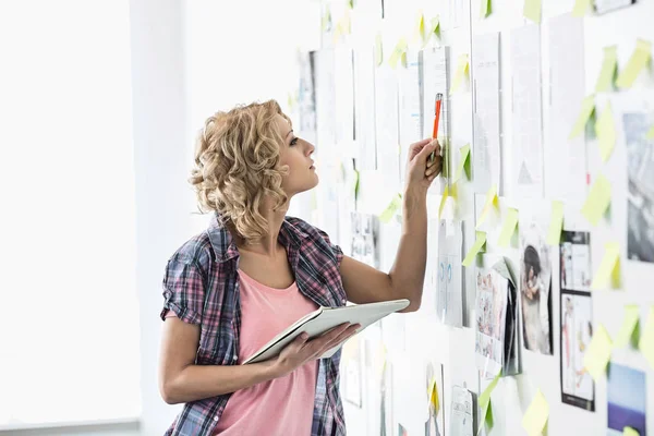 Kreative Geschäftsfrau analysiert Papiere — Stockfoto