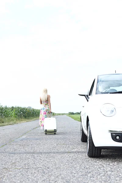 Frau mit Gepäck verlässt Auto — Stockfoto