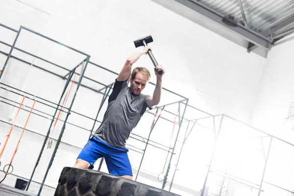 Man slår däck med slägga — Stockfoto