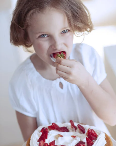 Menina com bolo comendo morango — Fotografia de Stock
