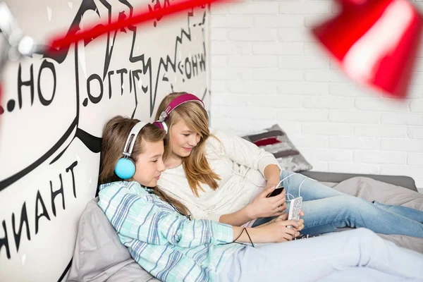 Relaxed sisters listening to music — Stock Photo, Image