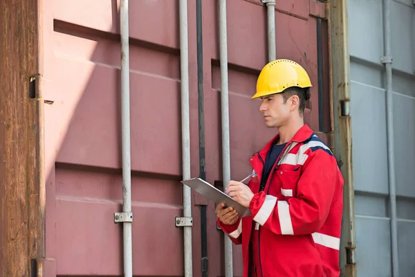 Trabajador masculino inspeccionando contenedor de carga — Foto de Stock