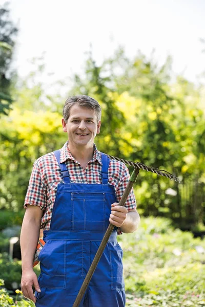 Jardinero seguro sosteniendo rastrillo — Foto de Stock