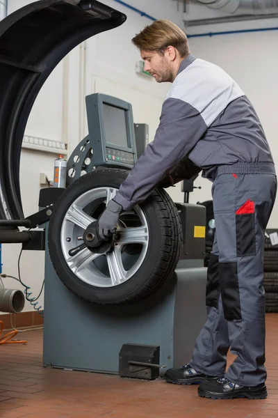 Mechanic repairing car's wheel — Stock Photo, Image