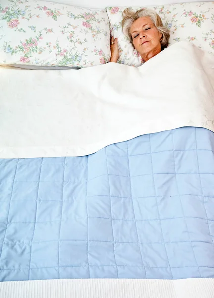 Seniorin schläft im Bett — Stockfoto