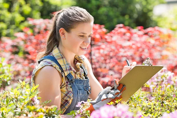 Supervisor femenino escribiendo en portapapeles — Foto de Stock