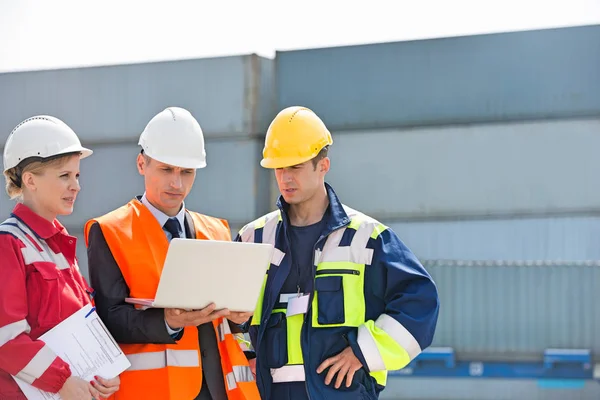 Trabajadores discutiendo sobre portátil — Foto de Stock