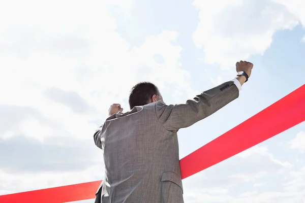 Businessman crossing finish line — Stock Photo, Image