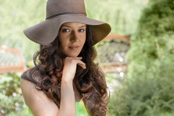 Woman wearing sun hat in park — ストック写真