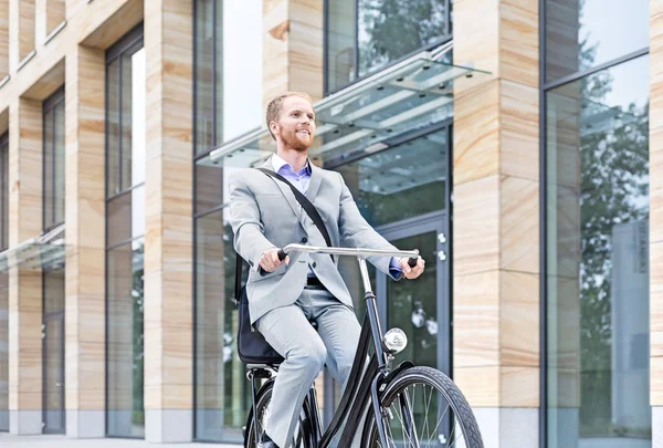 Улыбающийся бизнесмен на велосипеде — стоковое фото
