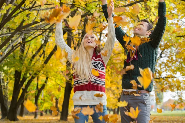 Pareja disfrutando de caída hojas de otoño — Foto de Stock