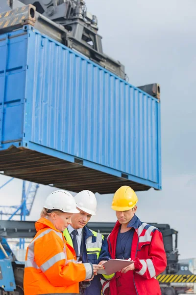 Workers discussing over clipboard — Stock Photo, Image