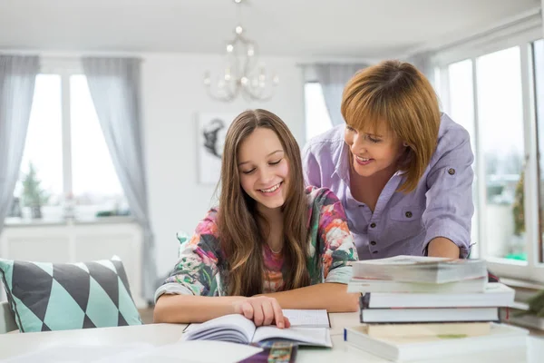 Matka pomáhá dcera v dělat domácí úkoly — Stock fotografie
