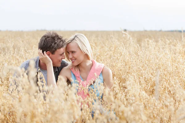 Casal relaxante em meio ao campo — Fotografia de Stock